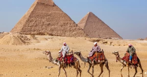 Scenic view of the Pyramids with camels in the desert near Giza, Egypt