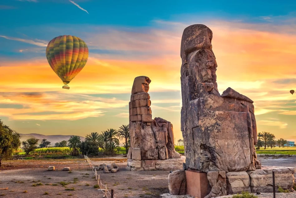 The Colossi of Memnon in Luxor Egypt featuring ancient statues of Pharaoh Amenhotep III
